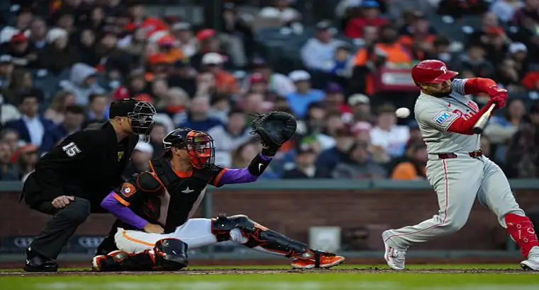 Philadelphia Phillies batter swinging at Oracle Park with Giants catcher and home plate umpire during April 9 2026 MLB game