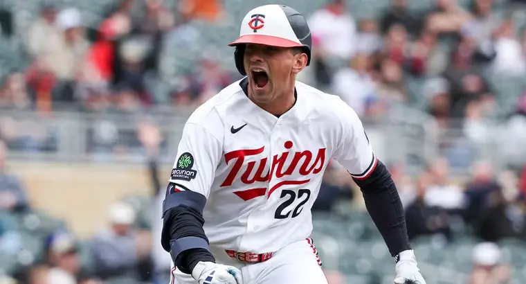 Minnesota Twins player number 22 celebrating with an open-mouthed roar after hitting a home run at Target Field
