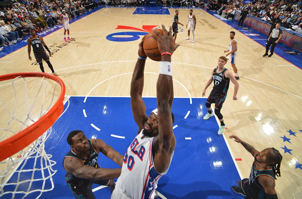 Philadelphia 76ers player dunking over Detroit Pistons defenders at Xfinity Mobile Arena during the April 4 2026 NBA game