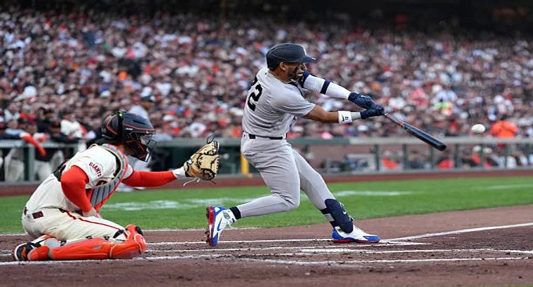 New York Yankees batter hitting the ball against San Francisco Giants catcher during MLB game at Oracle Park
