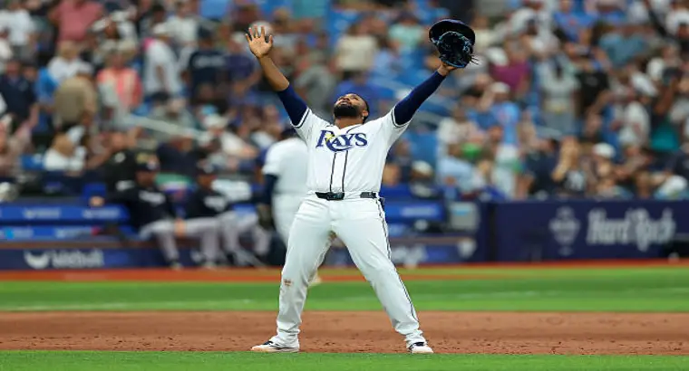 A Tampa Bay Rays player raises both arms skyward in celebration following a win over the New York Yankees at Tropicana Field in 2026