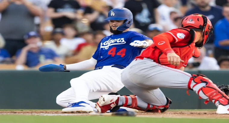 Teoscar Hernández of the Los Angeles Dodgers sliding into home plate as the Cincinnati Reds catcher attempts the tag during spring training at Camelback Ranch – Glendale, March 12, 2026