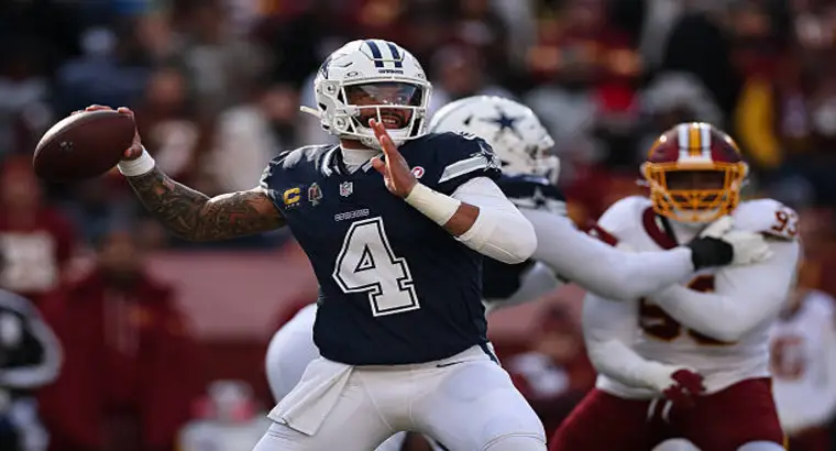 Dak Prescott #4 Dallas Cowboys quarterback throwing a pass under pressure from Washington Commanders pass rush during their NFL game