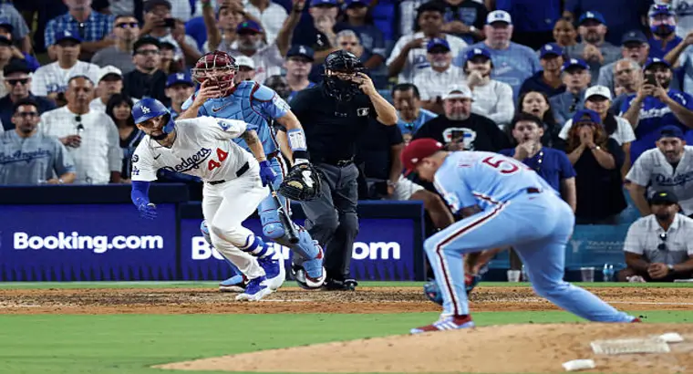 Dodgers batter #44 running toward first base as a Phillies pitcher follows through on his delivery during the October 9, 2025 MLB game at Dodger Stadium