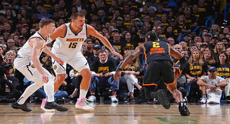 Denver Nuggets center Nikola Jokic (#15) in defensive stance guarding Oklahoma City Thunder guard Shai Gilgeous-Alexander (#2) during the 2024–25 NBA Playoffs Western Conference Semifinals.