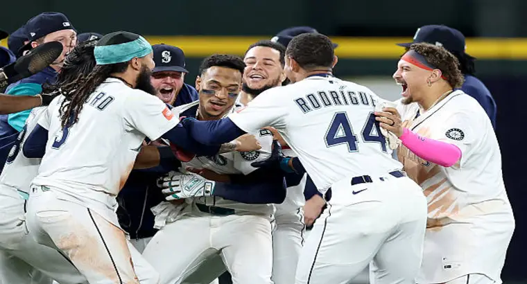 Seattle Mariners players mob each other in celebration after defeating Detroit Tigers 3-2 in 15 innings during the 2025 MLB postseason at T-Mobile Park